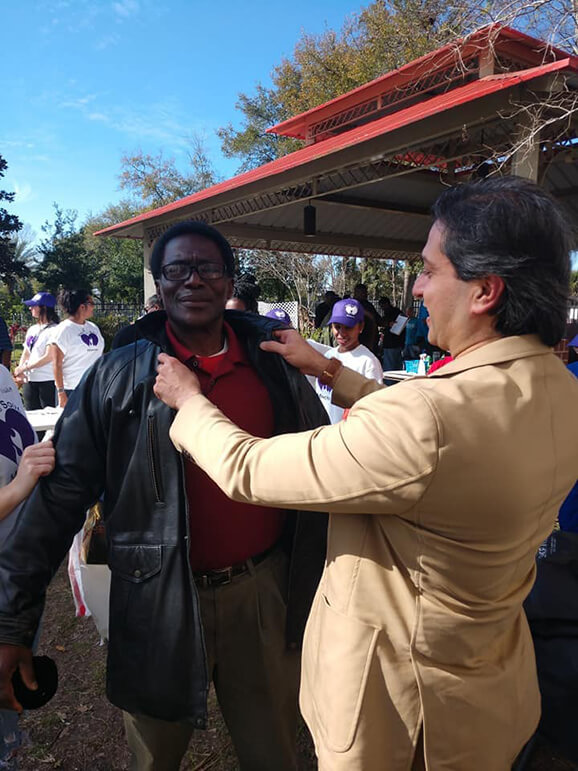 Dr. Gulani Helping a Man With a Jacket