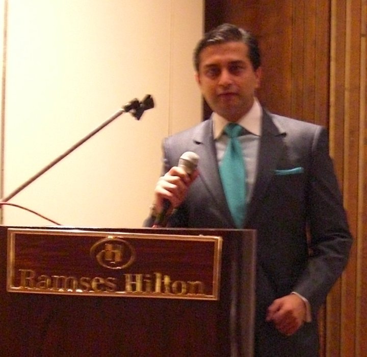 Dr. Gulani Giving a Lecture on a Podium